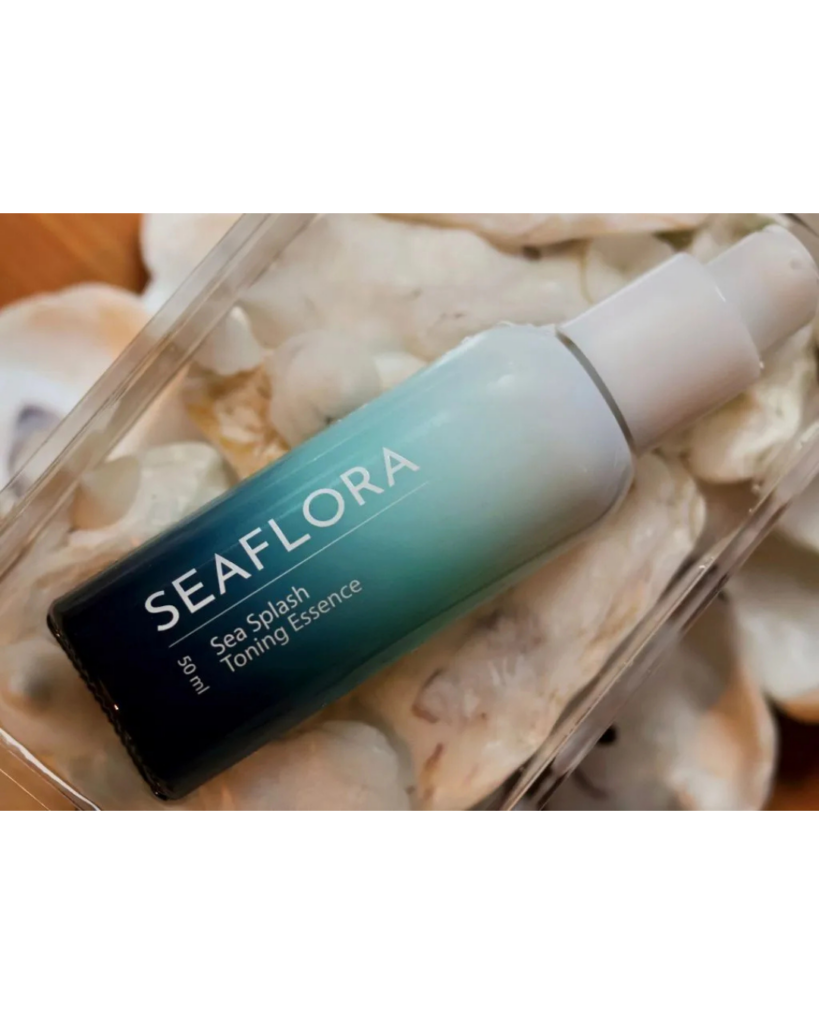 Bottle of Seaflora Sea Splash Toning Essence resting on a bed of white seashells.